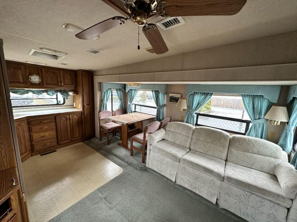 3 person couch, 4 person dining table, and part of the kitchen in the 1993 Travel Supreme