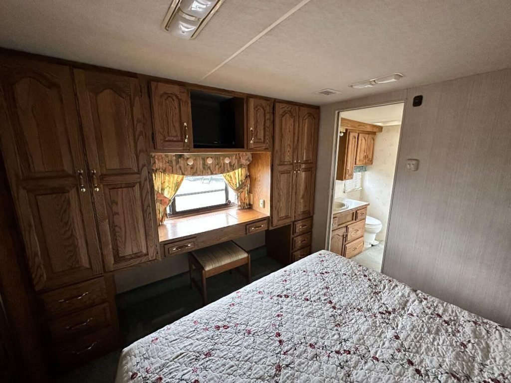 A view from the bedroom inside the 1993 Travel Supreme. The bathroom can be seen through the open doorway.