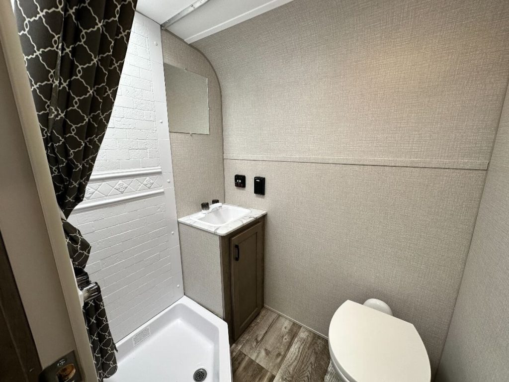 Bathroom with toilet, sink, and shower